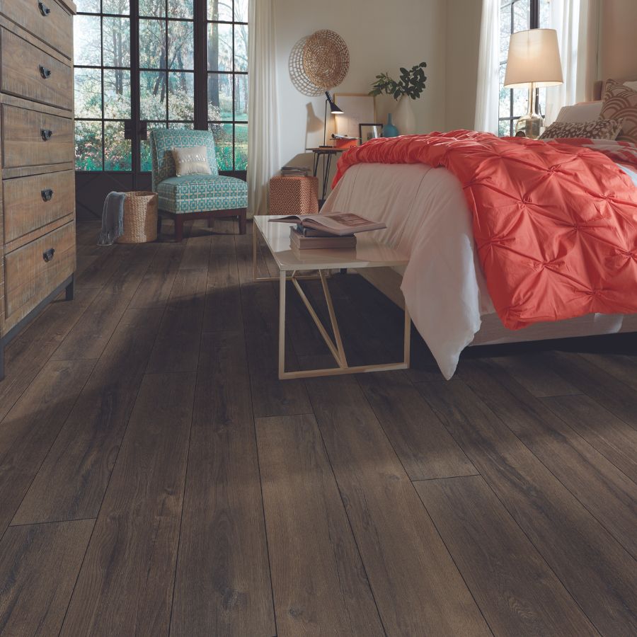 dark stained luxury vinyl plank flooring in a cozy bedroom